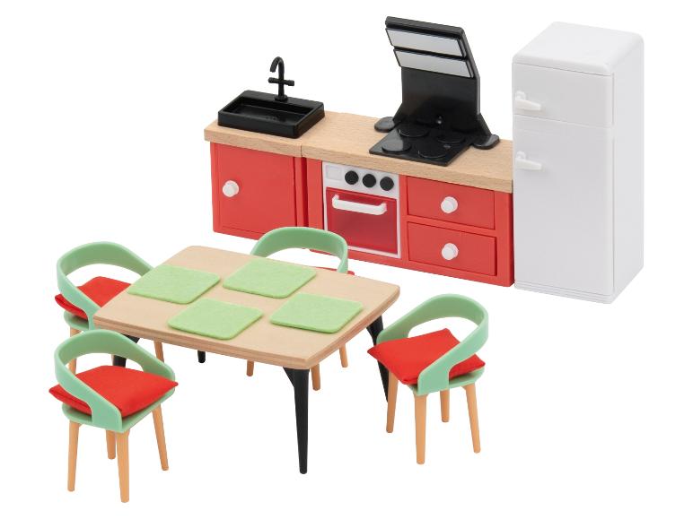 Speelgoedkeuken met rode kasten, witte koelkast en eettafel met vier stoelen.