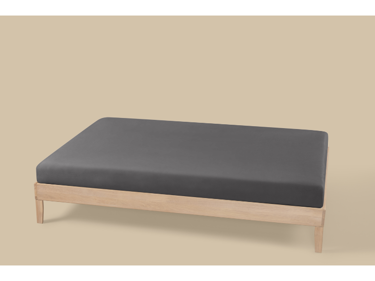 Houten bedframe met een donkergrijs hoeslaken op een lichte achtergrond.