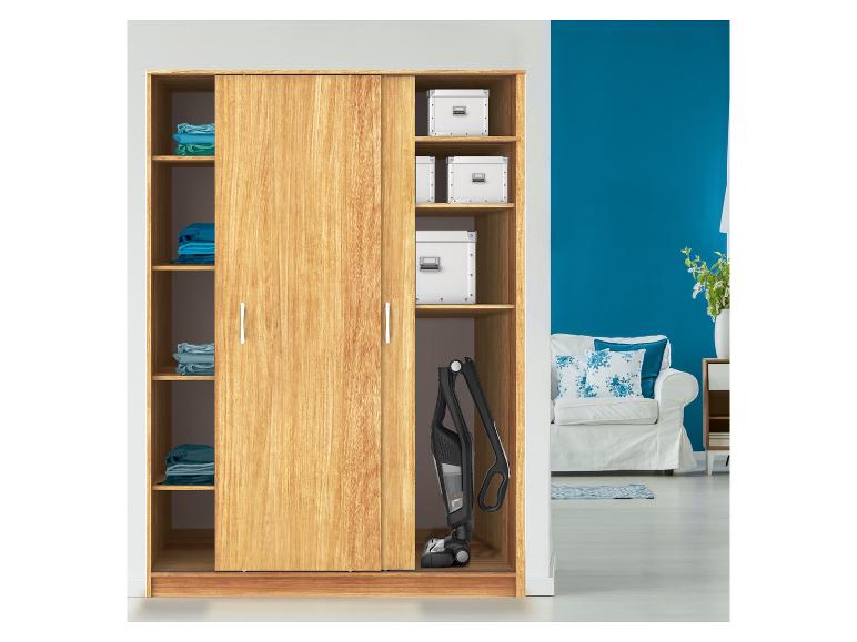 Houten kledingkast met schuifdeuren, opgevouwen kleding, opbergdozen en steelstofzuiger.