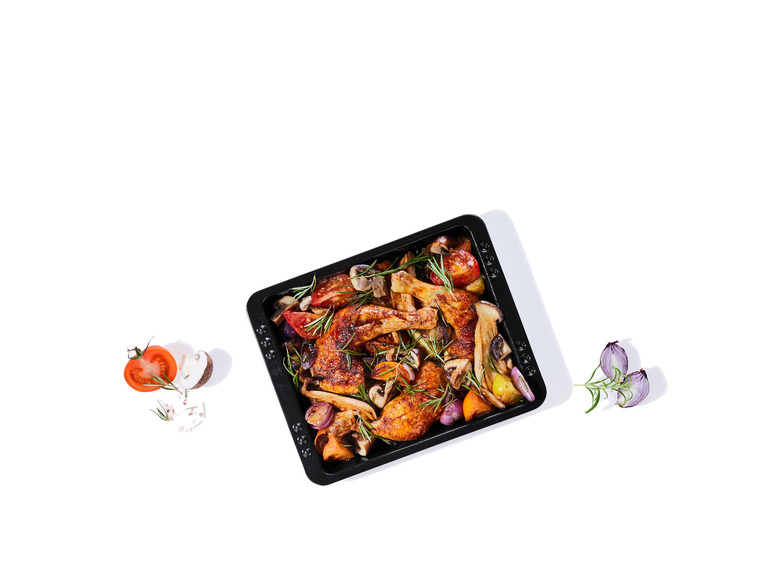 Geroosterde kip met champignons, tomaten en uien in een bakblik.