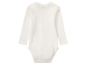 Witte baby romper met lange mouwen.