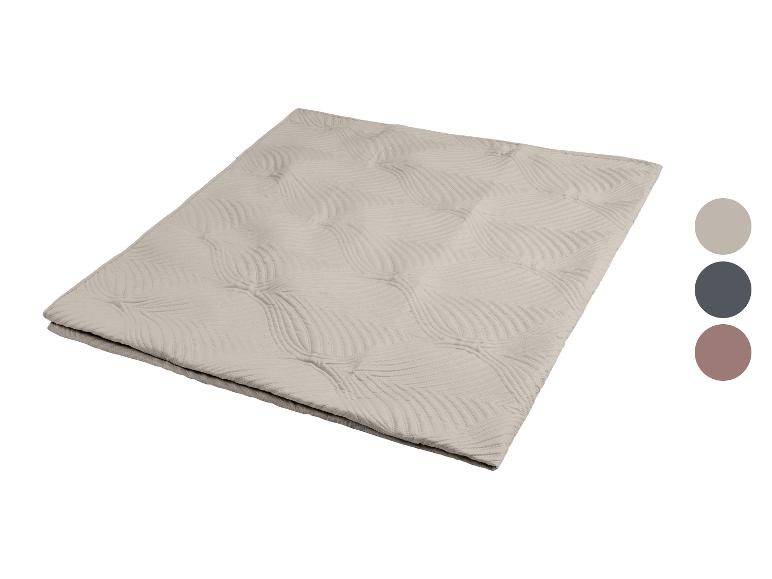 Beige deken met bladprint en drie kleurstalen.