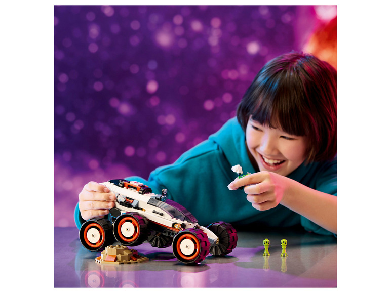 Een kind speelt met een LEGO-voertuig en aliens.