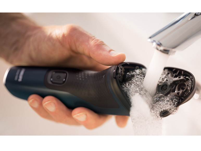 Een Philips scheerapparaat wordt onder de kraan schoongemaakt.