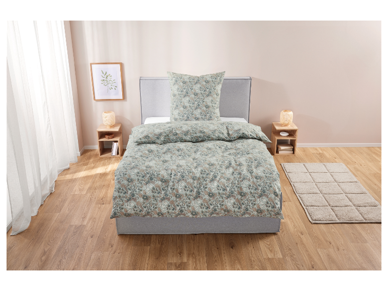 Bloemen beddengoed in groene en beige tinten op een grijs bed.