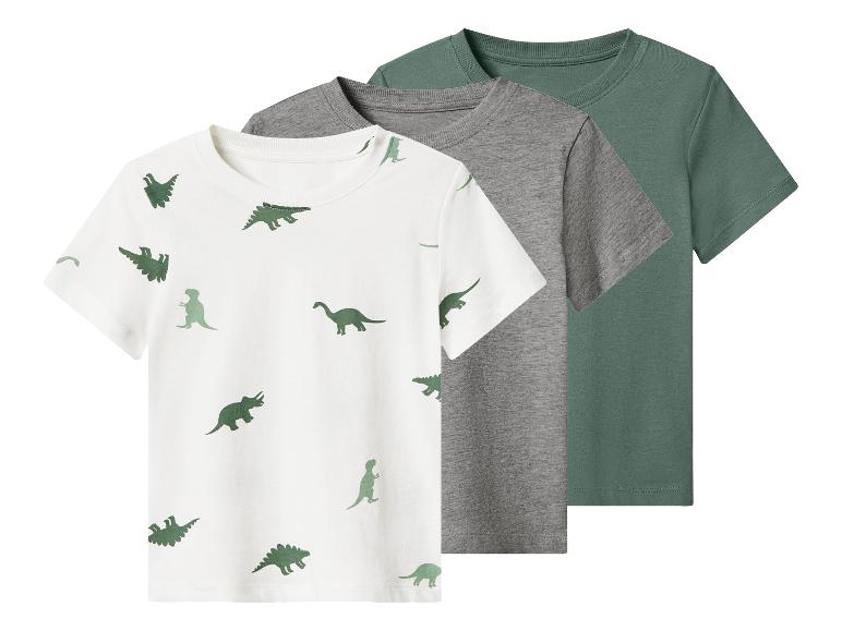 Drie kinder T-shirts met korte mouwen: één wit met groene dinosaurussen, één grijs en één groen.