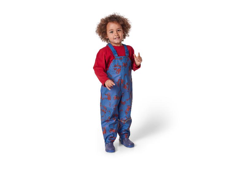 Een kind draagt een blauwe Spiderman-overall en regenlaarzen.