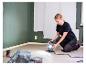 Vrouw schildert kamer met LIVARNO® werklamp.