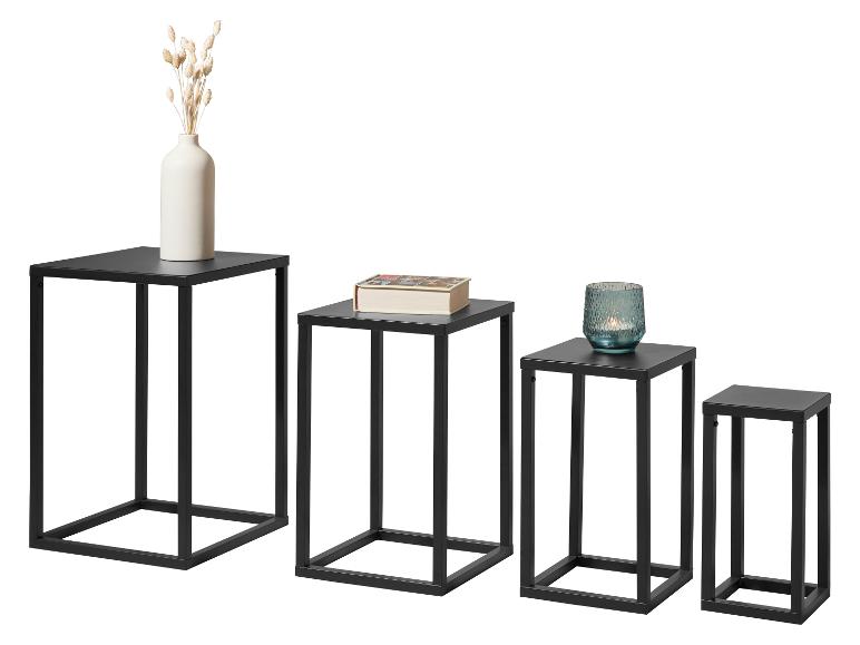 Set van vier zwarte metalen bijzettafels van verschillende hoogtes met decoratieve items.