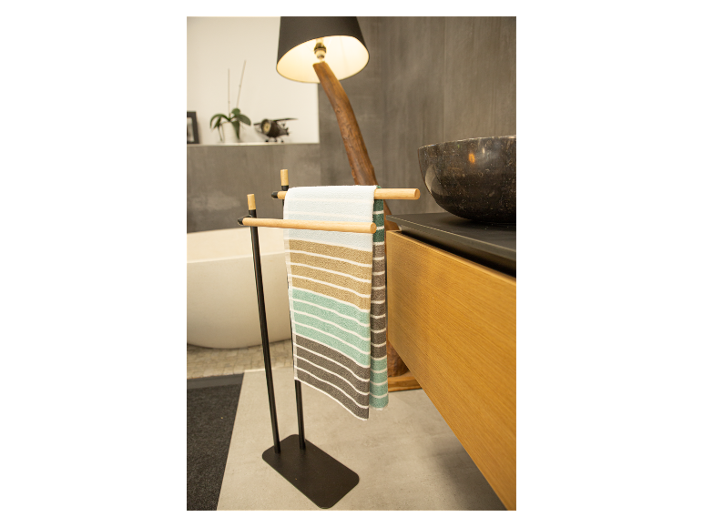 Zwarte handdoekenrek met gestreepte handdoeken in een moderne badkamer.
