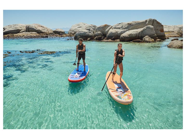 Twee mensen op stand-up paddleboards in turquoise water bij rotsen.