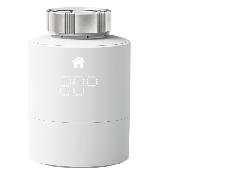 Witte slimme thermostaat met digitaal display en draaiknop.