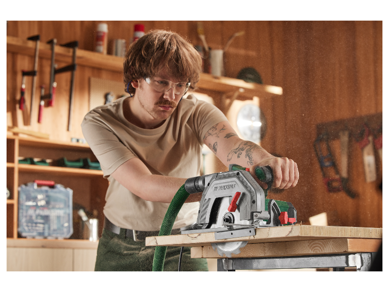 Een timmerman gebruikt een Parkside cirkelzaag om hout te zagen.