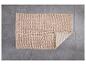 Een beige badmat met een zachte textuur.