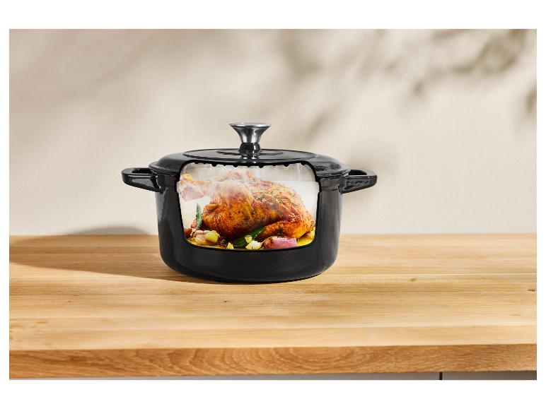 Een gebraden kip in een zwarte gietijzeren pot.