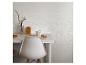 Witte eettafel met stoel, mok en decoratieve houten elementen.