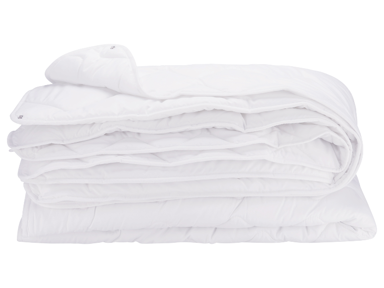 Een netjes opgevouwen wit, zacht en pluizig dekbed.