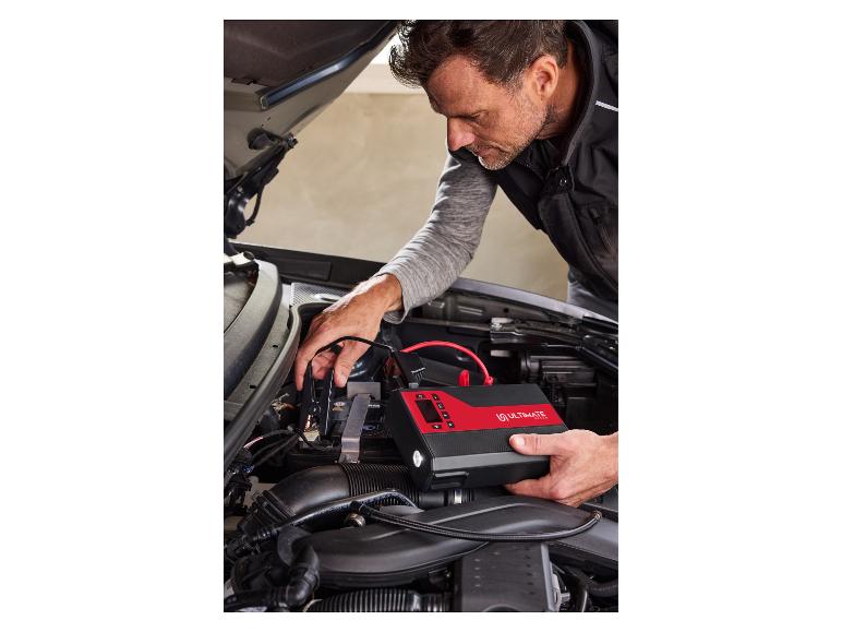 Man gebruikt een Ultimate Speed starthulp in een automotorruimte.