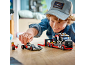 Jongen speelt met een speelgoed raceautotransporter en een raceauto.