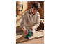 Een vrouw schuurdt hout met een Parkside schuurmachine in haar werkplaats.