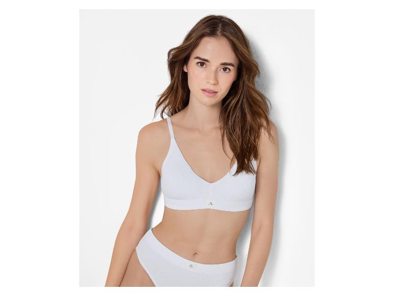Vrouw in witte geribbelde katoenen bralette en slip.