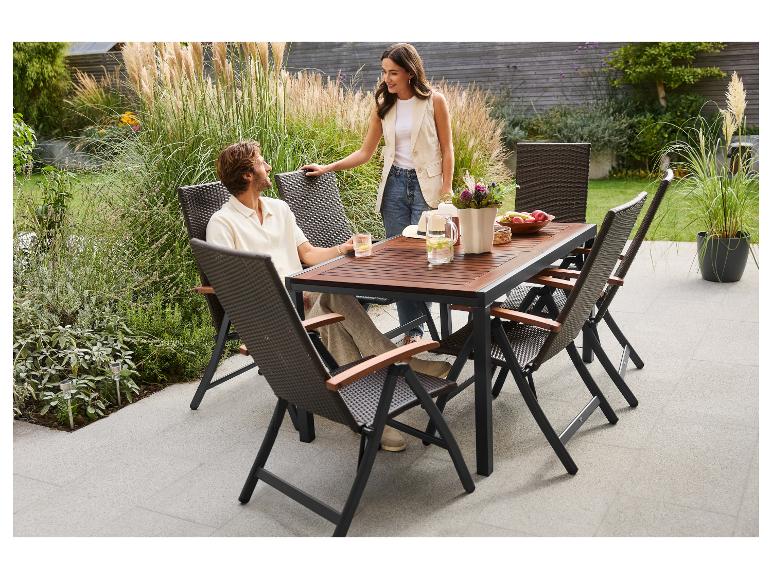 Paar zit aan tuintafel met rotan stoelen op terras.