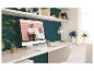 Werkplek met computer die een behangwinkel toont, bureau, planken en planten.