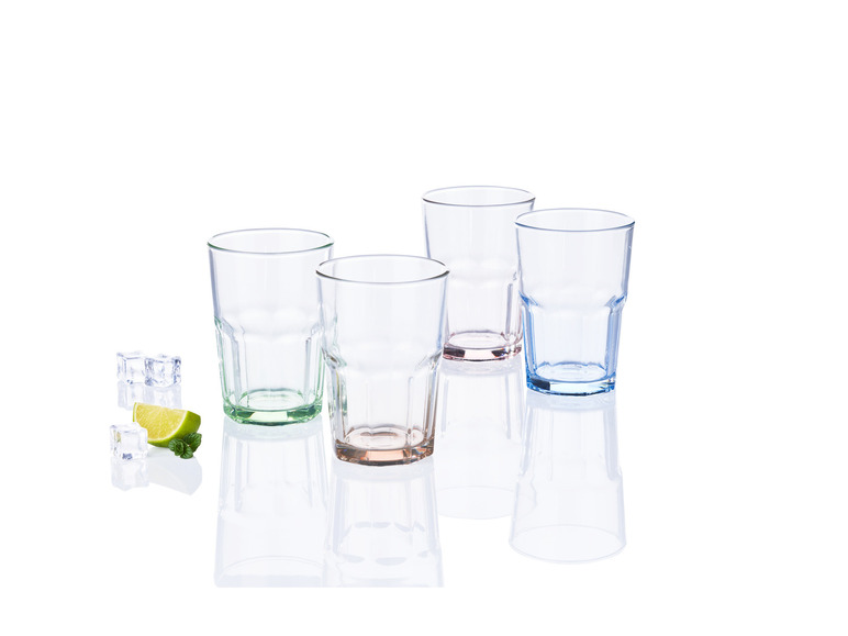 Vier glazen in verschillende kleuren met ijs en limoen.