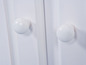 Twee witte knoppen op een witte deur.