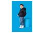 Jongen in een marineblauwe gewatteerde jas, jeans en witte sneakers, staand naast een blauwe sokkel.