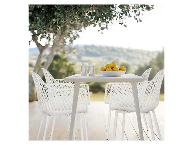 Witte buitentafel en stoelen met een schaal citroenen en glazen water op een terras.