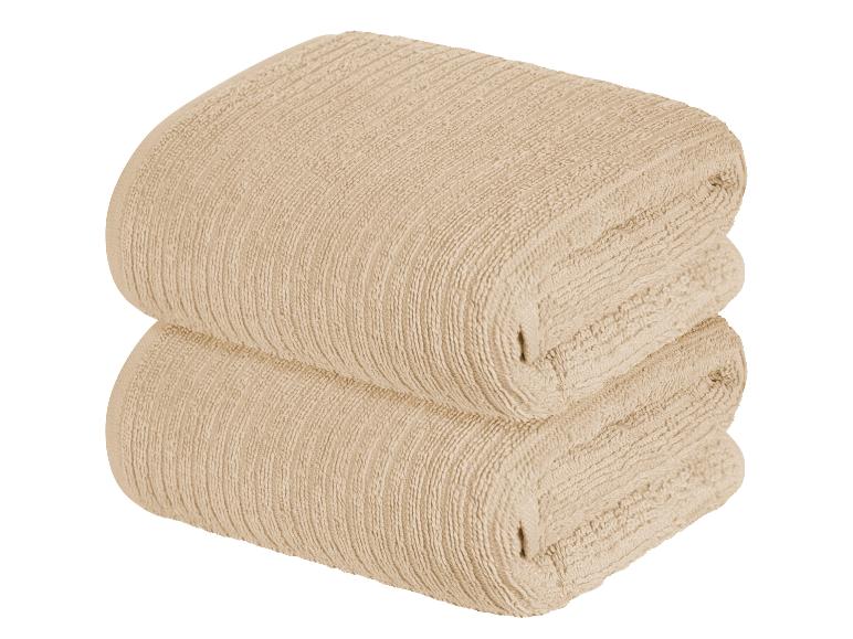 Twee beige, zachte, handdoeken met textuur.