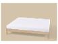 Een wit matras op een licht houten bedframe, tegen een beige achtergrond.