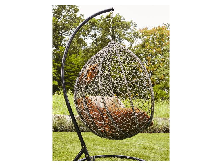 Eierstoel met bruine kussens in een tuinomgeving