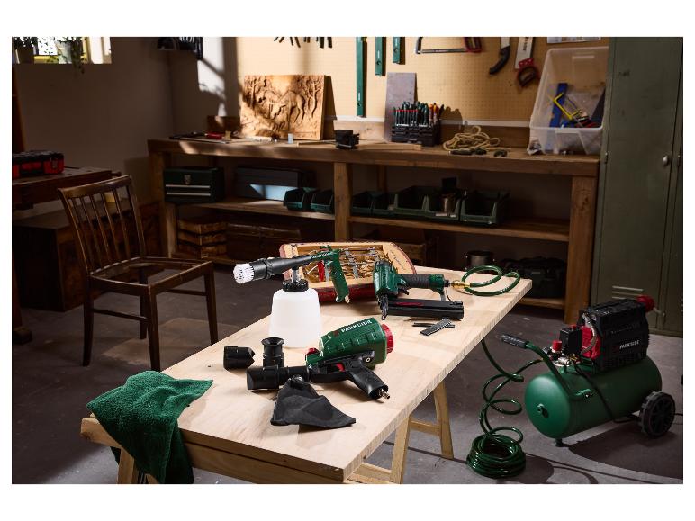 Parkside pneumatisch gereedschap, inclusief compressor, spijkerpistool en reinigingspistool, op een werkbank.