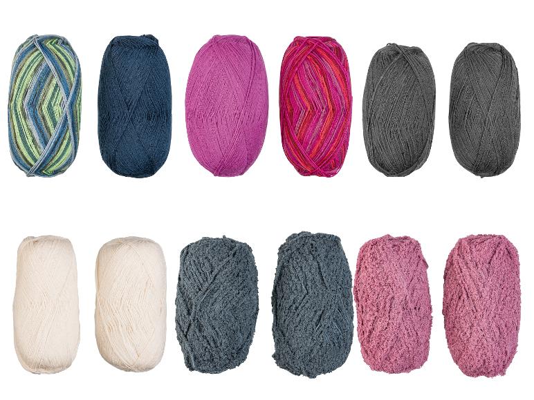 Een collectie garenbollen in diverse kleuren en texturen, waaronder effen, gemêleerd en pluizig.