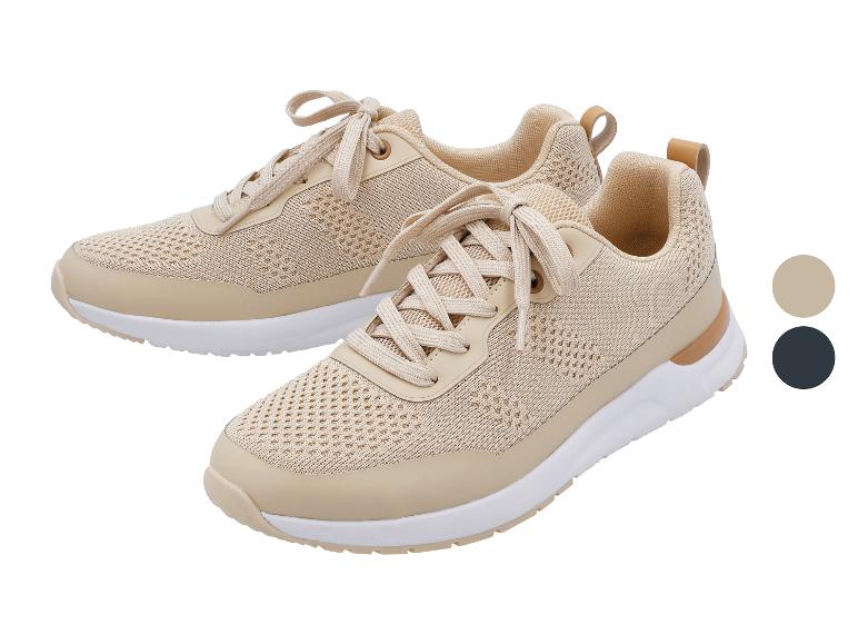 Twee beige sneakers met veters, witte zolen en lichtbruine details.