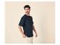 Man in een marineblauw T-shirt en beige broek, kijkt opzij.