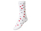Witte wollen sok met rode en grijze stippen.