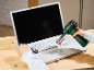 Accu-blower reinigt laptoptoetsenbord, met een vork in de andere hand.