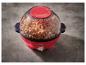 Rode popcornmachine gevuld met popcorn op een grijs oppervlak