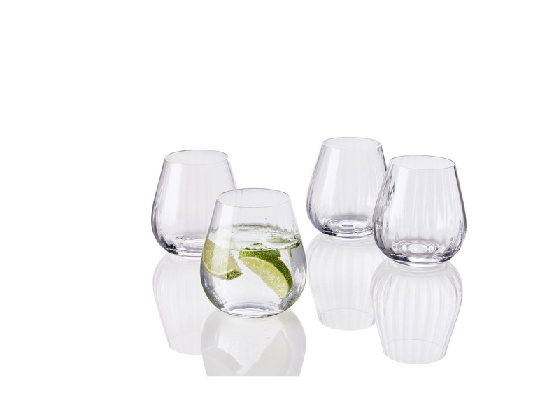 Vier glazen, waarvan één met water en een schijfje limoen.