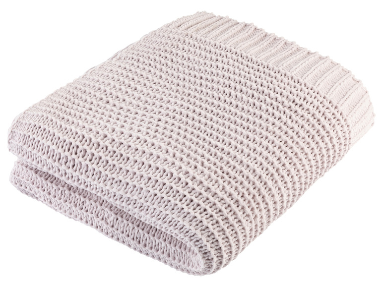Een zachte, gebreide deken in een lichte kleur.