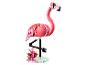 Lego flamingo met roze en witte stenen, zwarte poten en tropische bloemen op een basis.