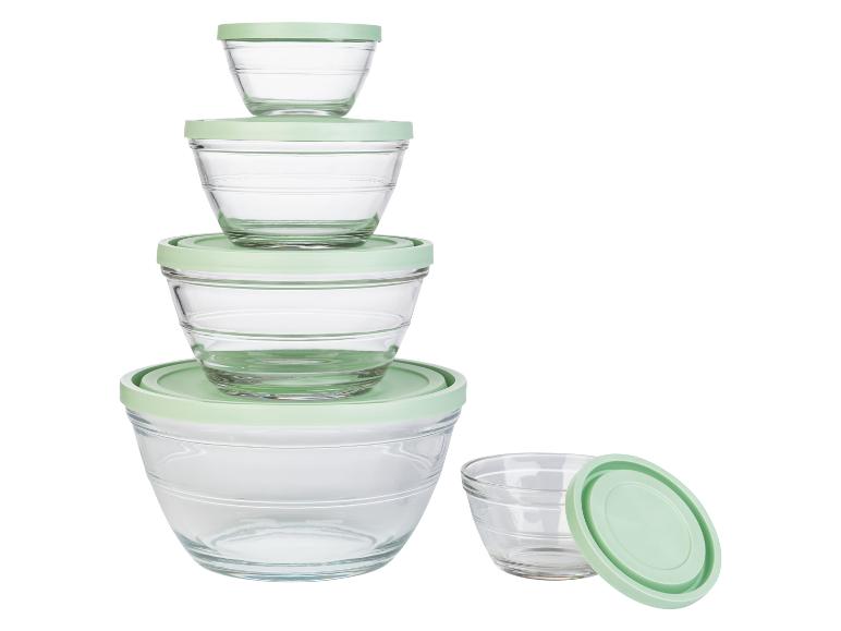 Een set glazen kommen met groene deksels.