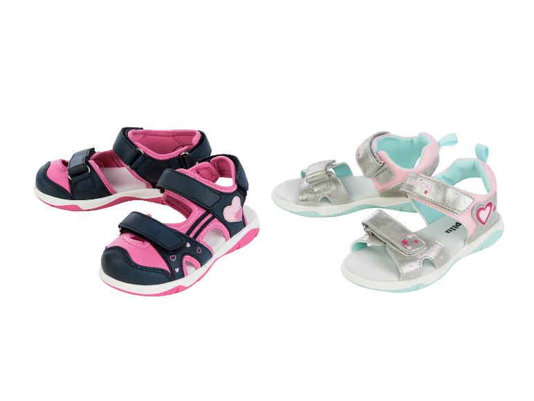 Twee paar roze en blauwe kindersandalen met hartjes en sterren.