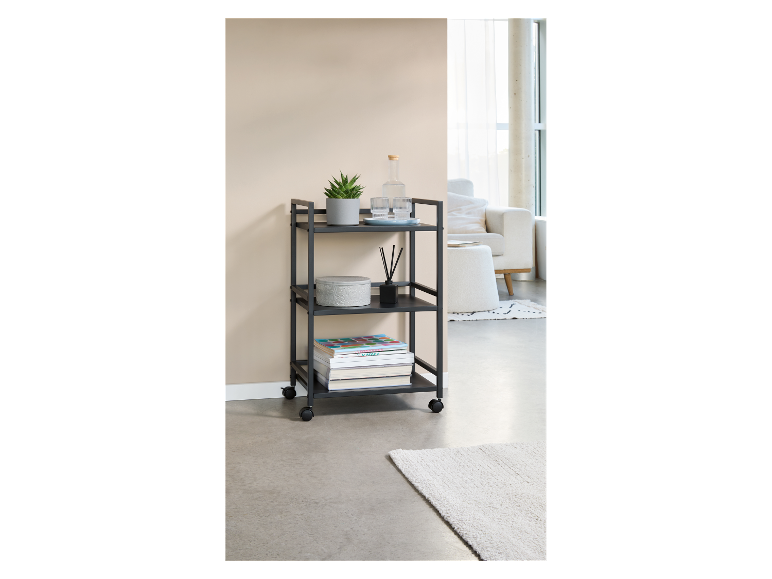 Een drielaags zwart metalen karretje, ideaal voor het opbergen van boeken, planten en andere spullen.