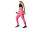Vrouw in zwarte sportbeha en roze legging met dumbbells.