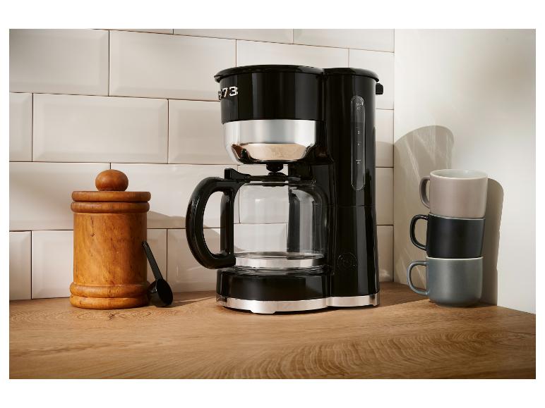 Zwarte Smeg koffiezetapparaat op een houten aanrecht.