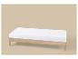 Licht houten eenpersoonsbed met wit matras op een beige achtergrond.